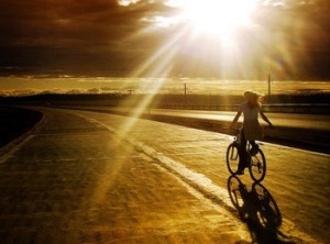 fată pe bicicletă, peisaj (revistaartasicredinta.ro)